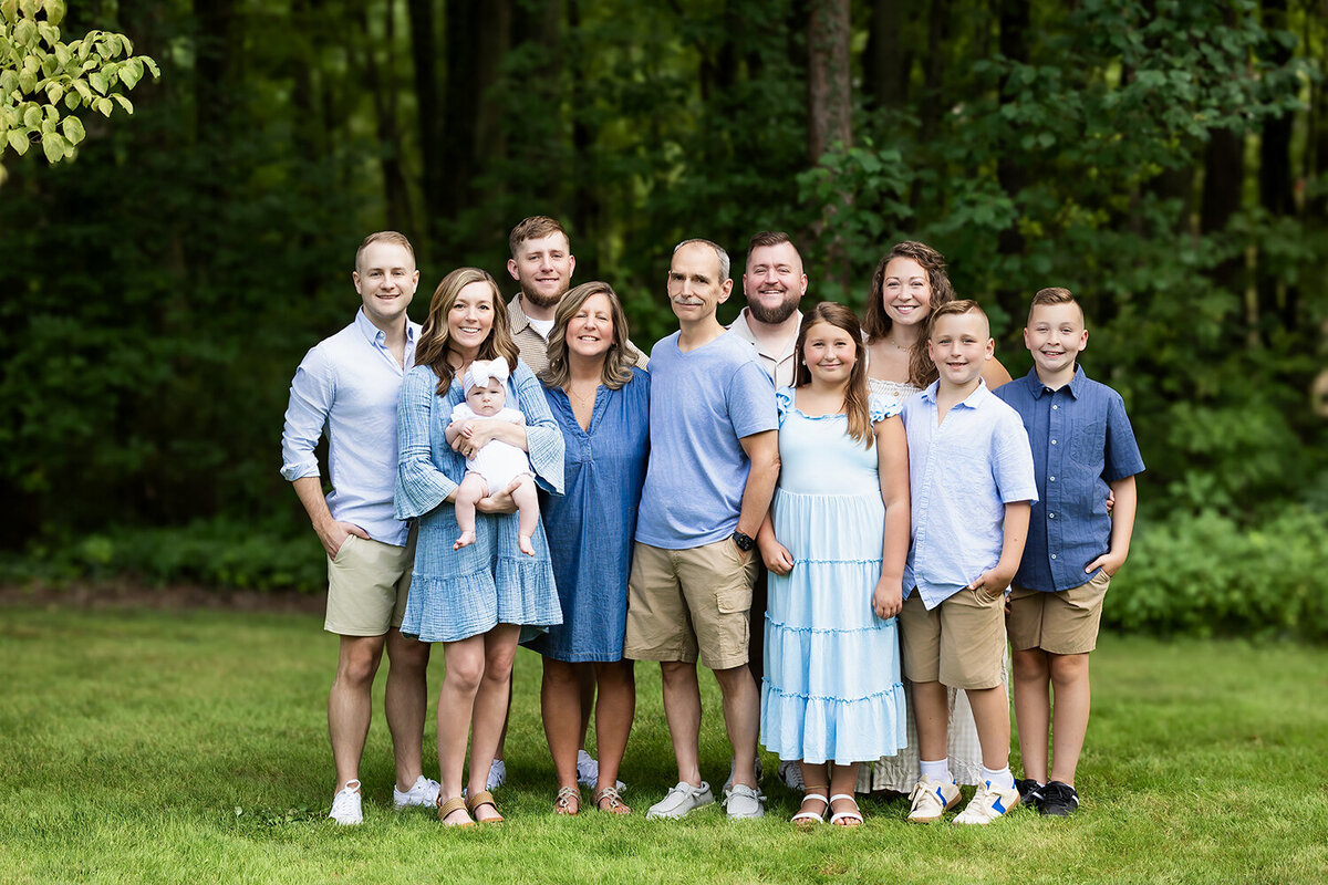 extended family smiling for camera at their session wearing beautiful blues and neutrals 