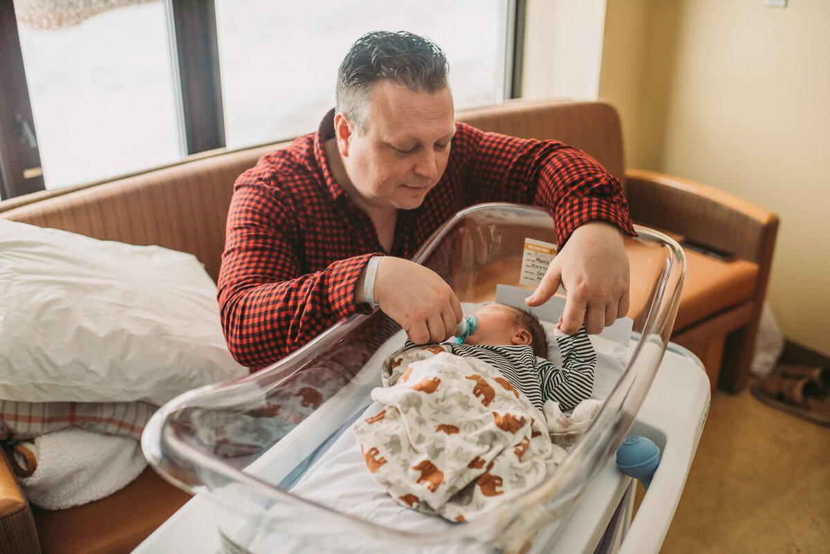 dad comforting newborn in hospital