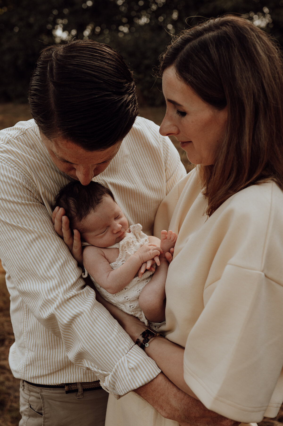 Koppel kijkt liefdevol naar hun baby tijdens newbornshoot