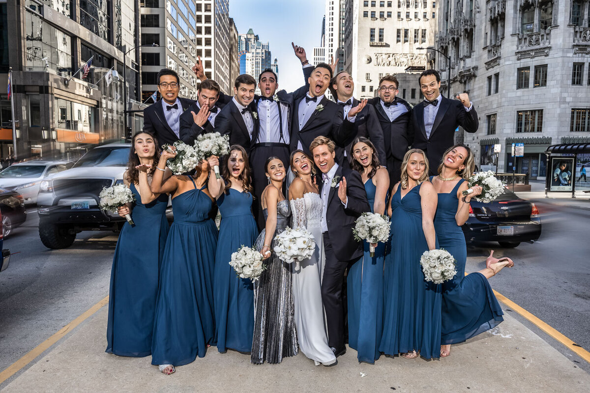 A bride and groom pose with their wedding party