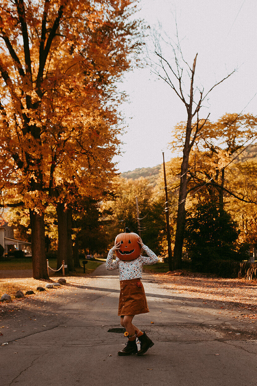 girl in the street wearing a pumpkin head
