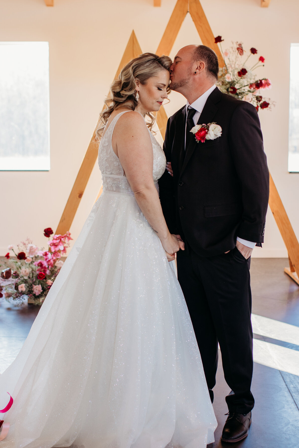 The groom kisses the brides forehead during an intimate moment at Ivy Black with a Duluth wedding photographer, S Jacobson Photography.