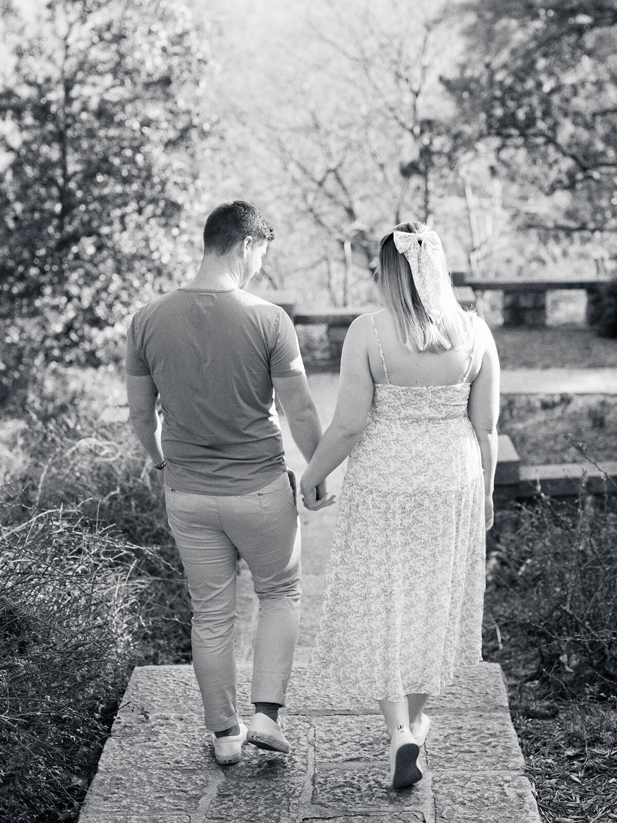 A couple holding hands while walking down the stairs at a Richmond maternity photography session by Katie Stansfield Photography.