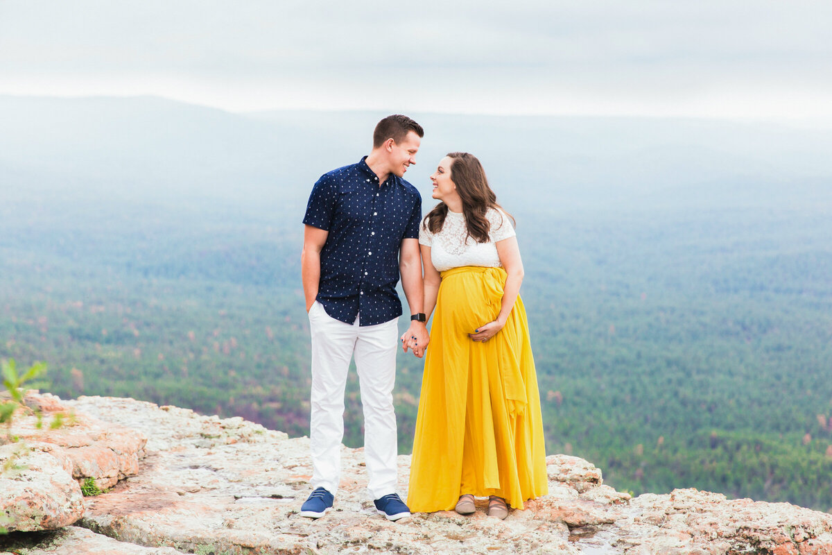 mom and dad to be holding hands and baby bump