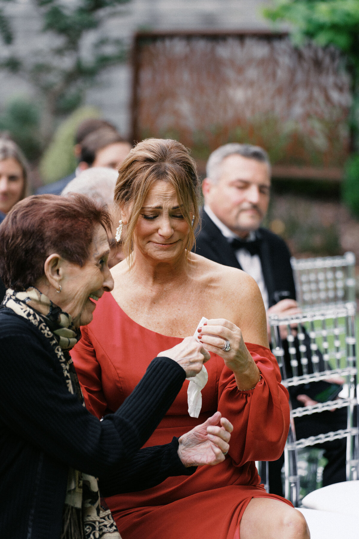 Guest wiping tears during outdoor wedding ceremony at Sapphire Creek Winery