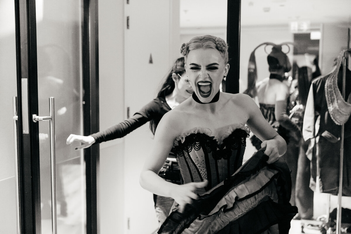 Moulin Rouge de Musical performer backstage lacht breeduit.