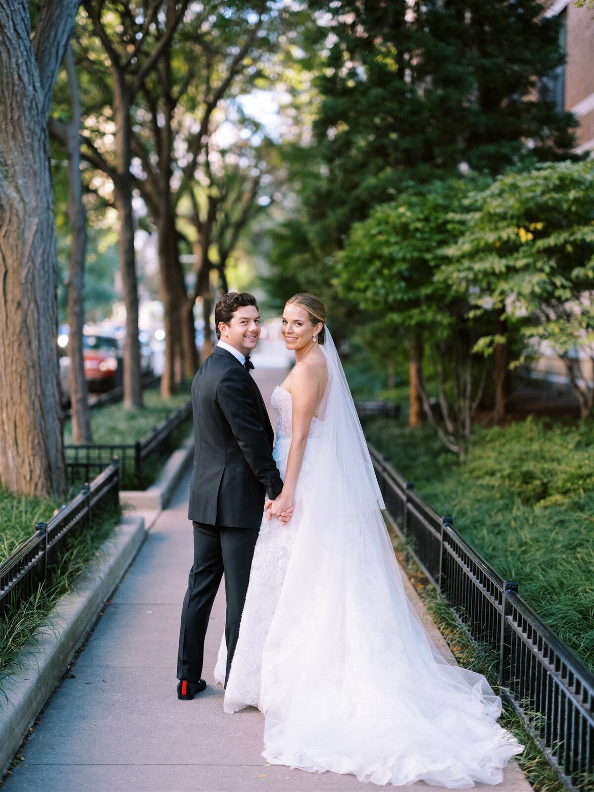 A photo of the bride and groom on a tree lined street in Chicago.