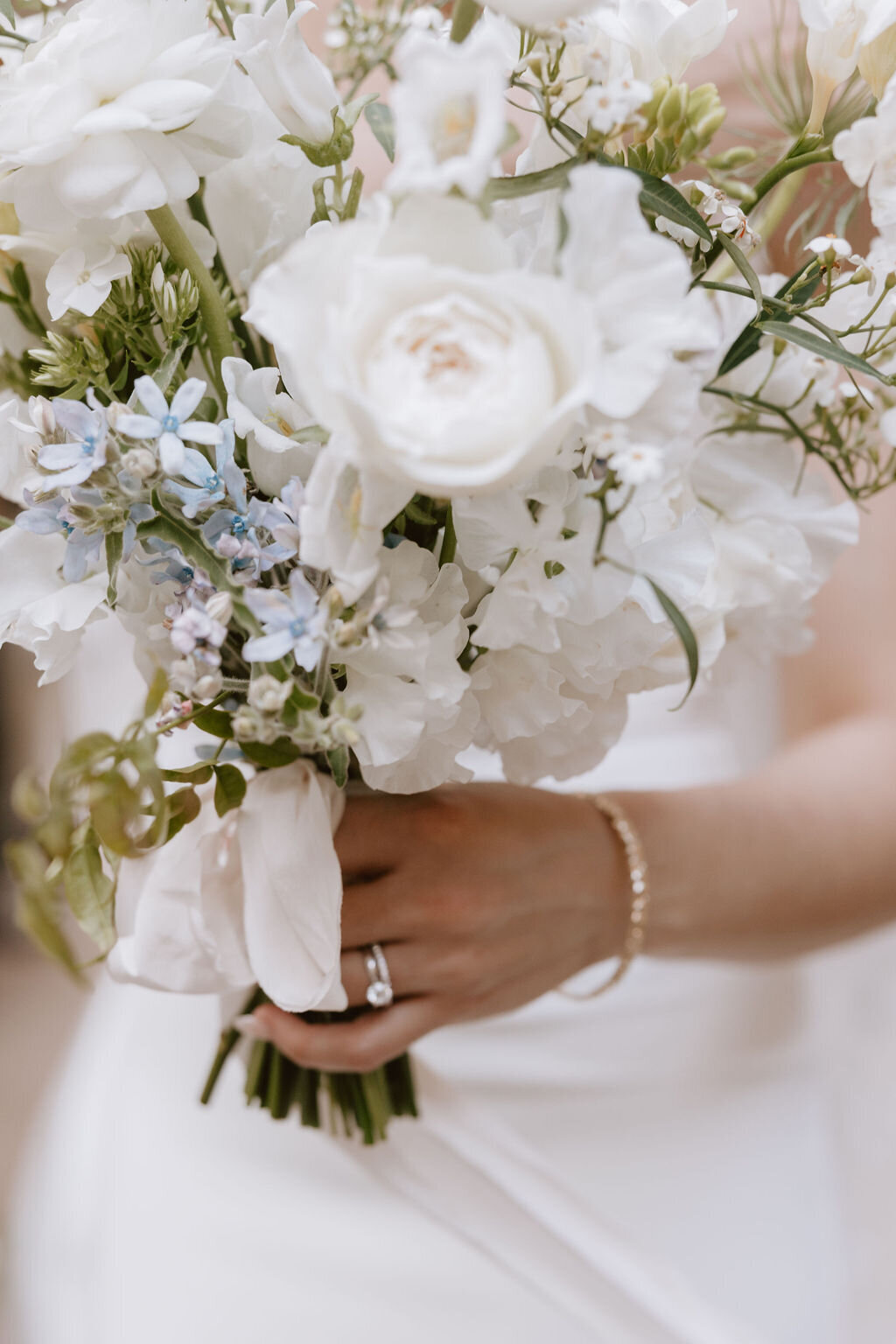 close up of brides ring holding wedding bouquet