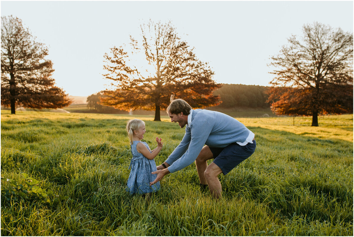 Daughter’s cute, excited face lights up as her dad surprises her in a grass field during hide-and-seek