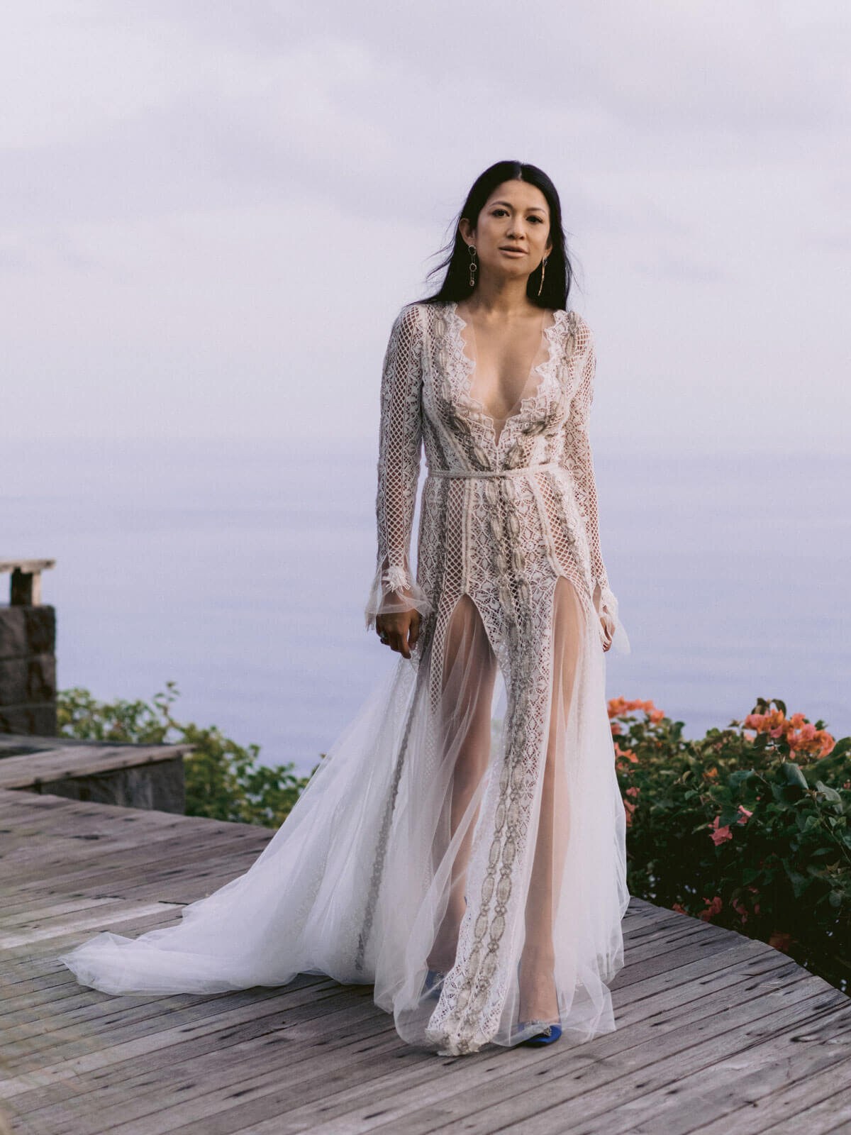 The gorgeous bride in her daring wedding dress, the ocean is in the background in Khayangan Estate, Bali, Indonesia. Image by Jenny Fu Studio