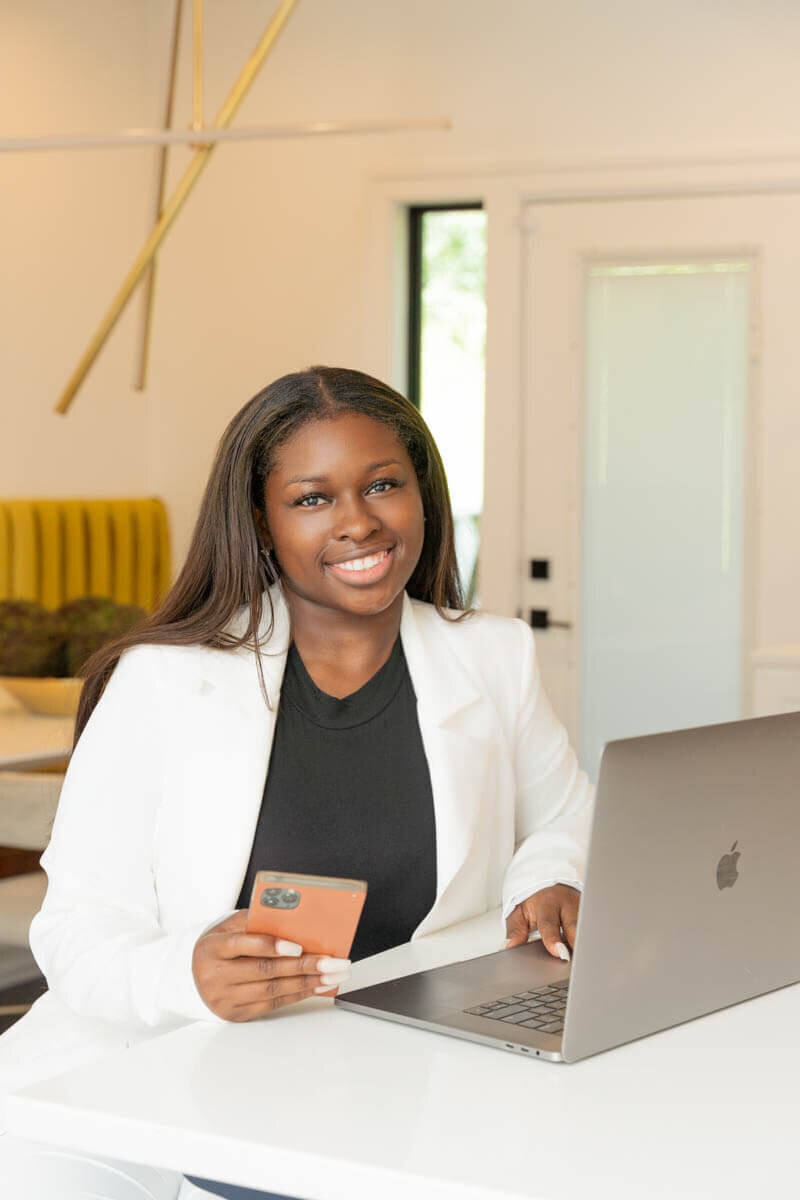 realtor is on laptop smiling at a baltimore branding photographer