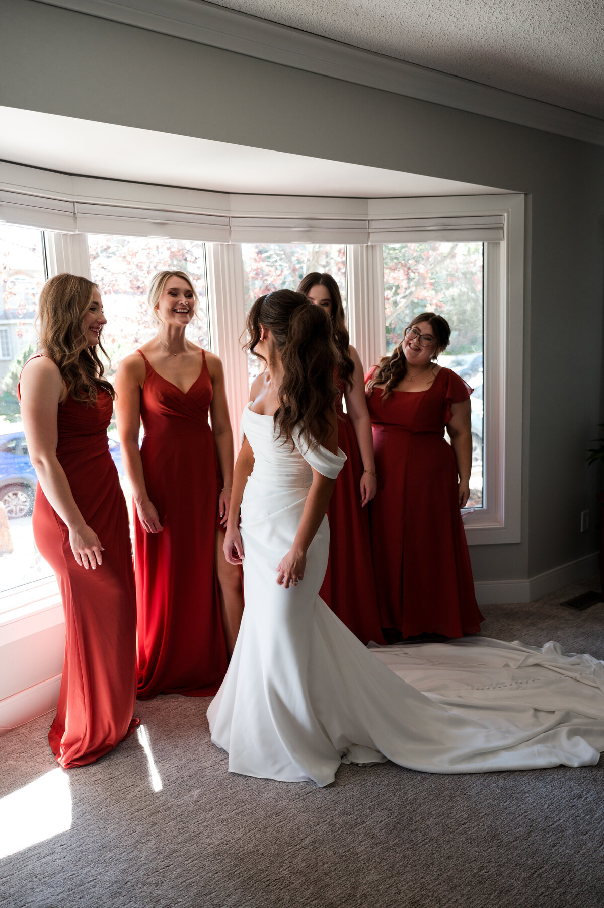 bride showing off her dress to wedding party