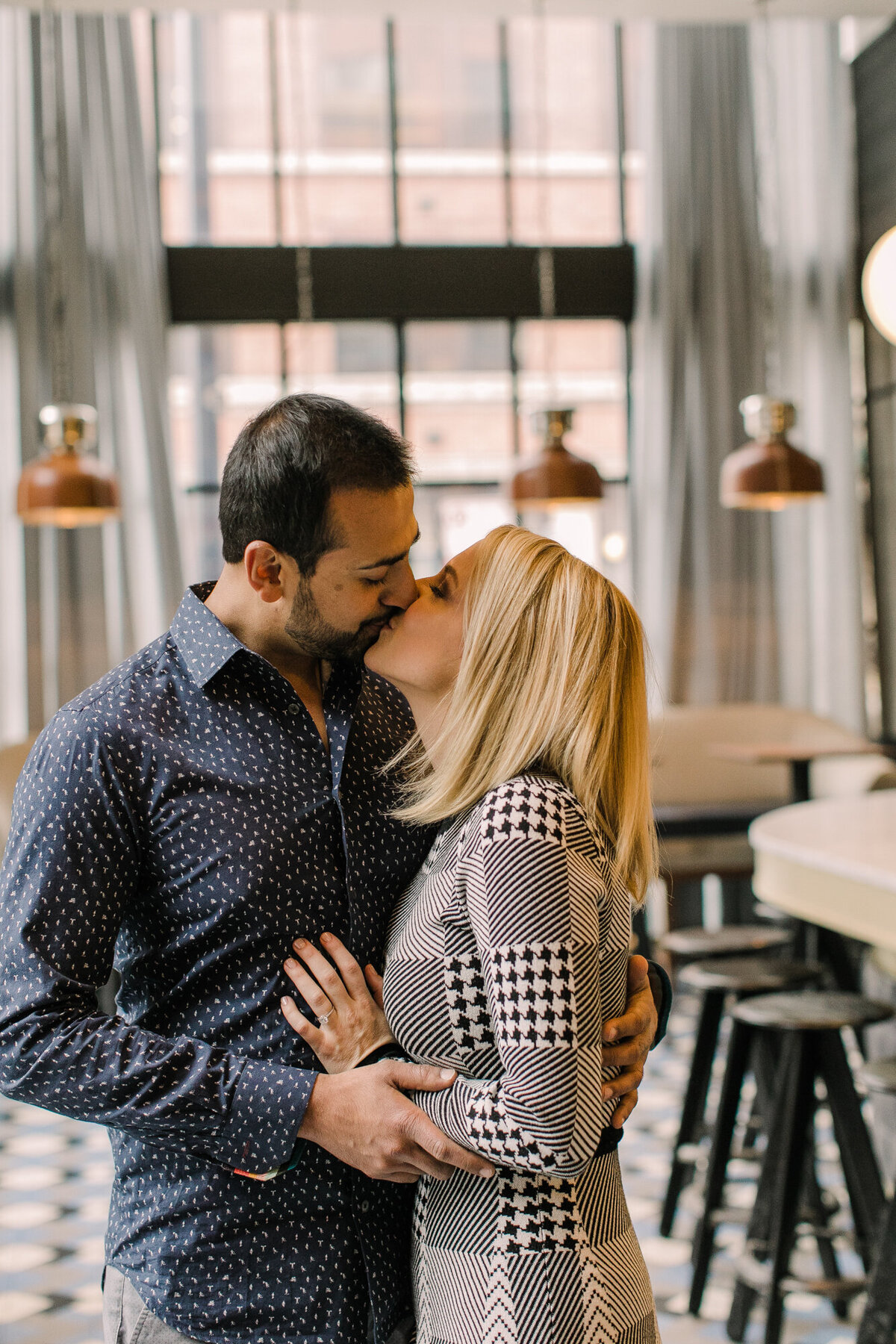 A couple poses for an engagement photo in their favorite West Loop bar in Chicago