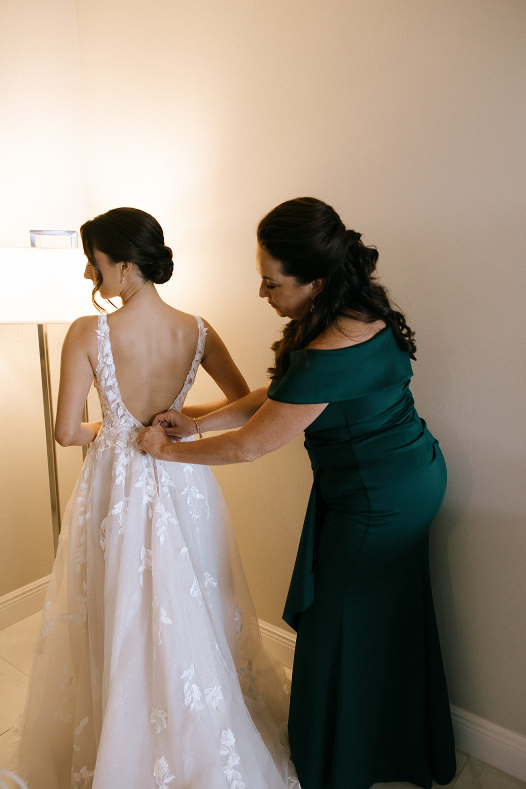 bride dress zipping at bella collina weddings & events​