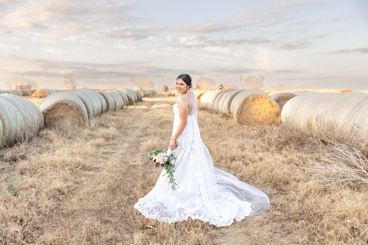 bride turns waking through roundbales at sunset ranch wedding San Antonio Texas by Firefly Photography