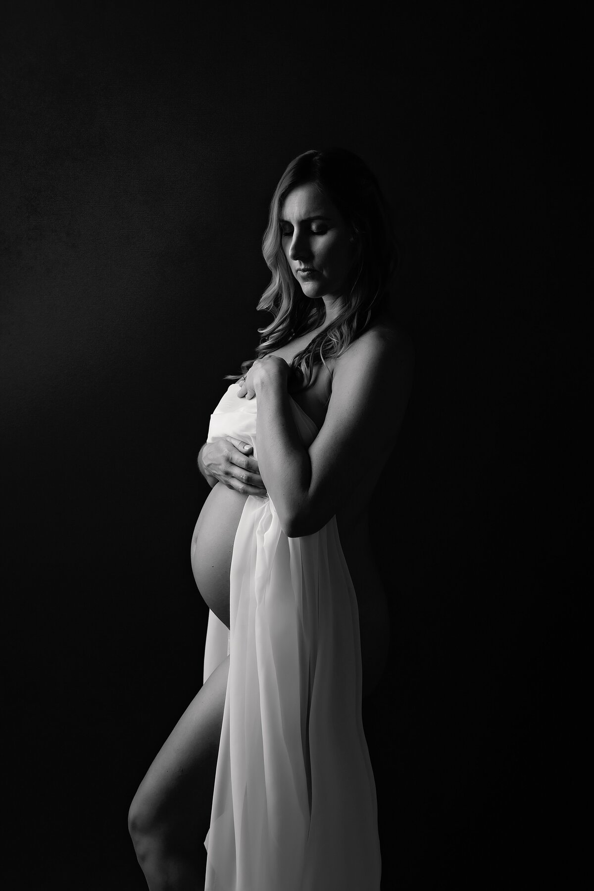 Intimate nude boudoir glamour maternity shoot in black and white.