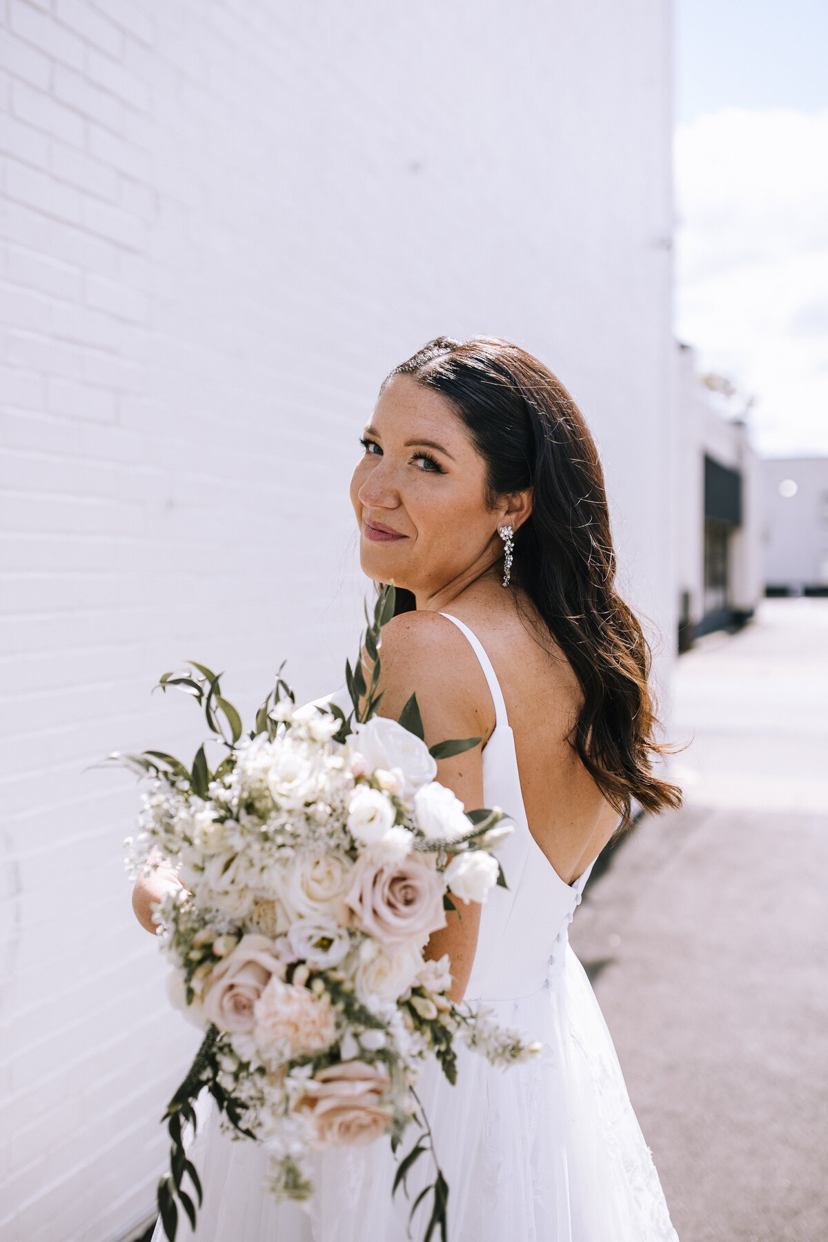 Bride holding a bouquet by Gold Dust Floral at Sewickley Quarter.