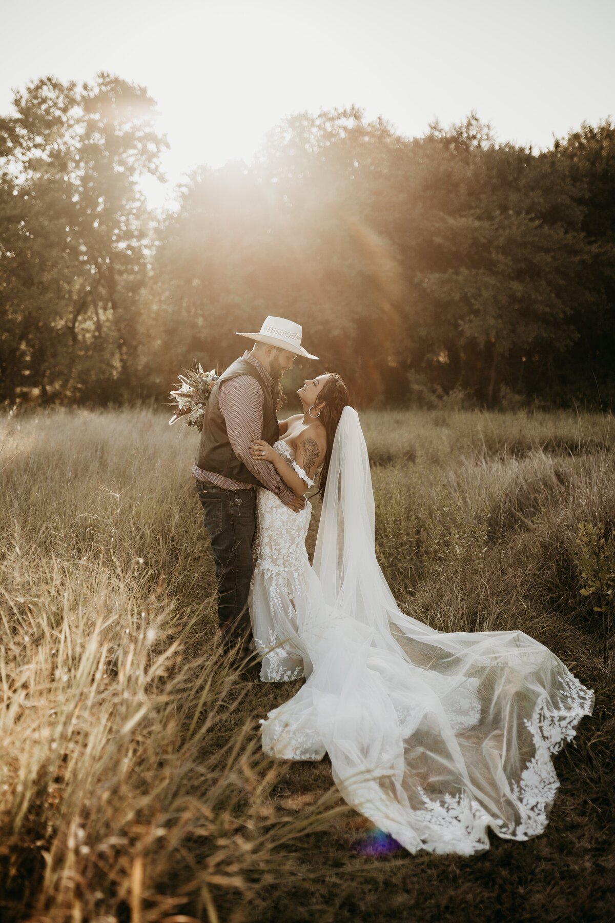 bride and groom looking at each other under sun flares