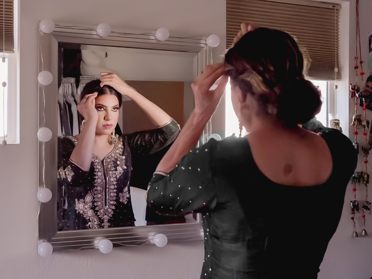 Indian bride getting ready in front of the mirror