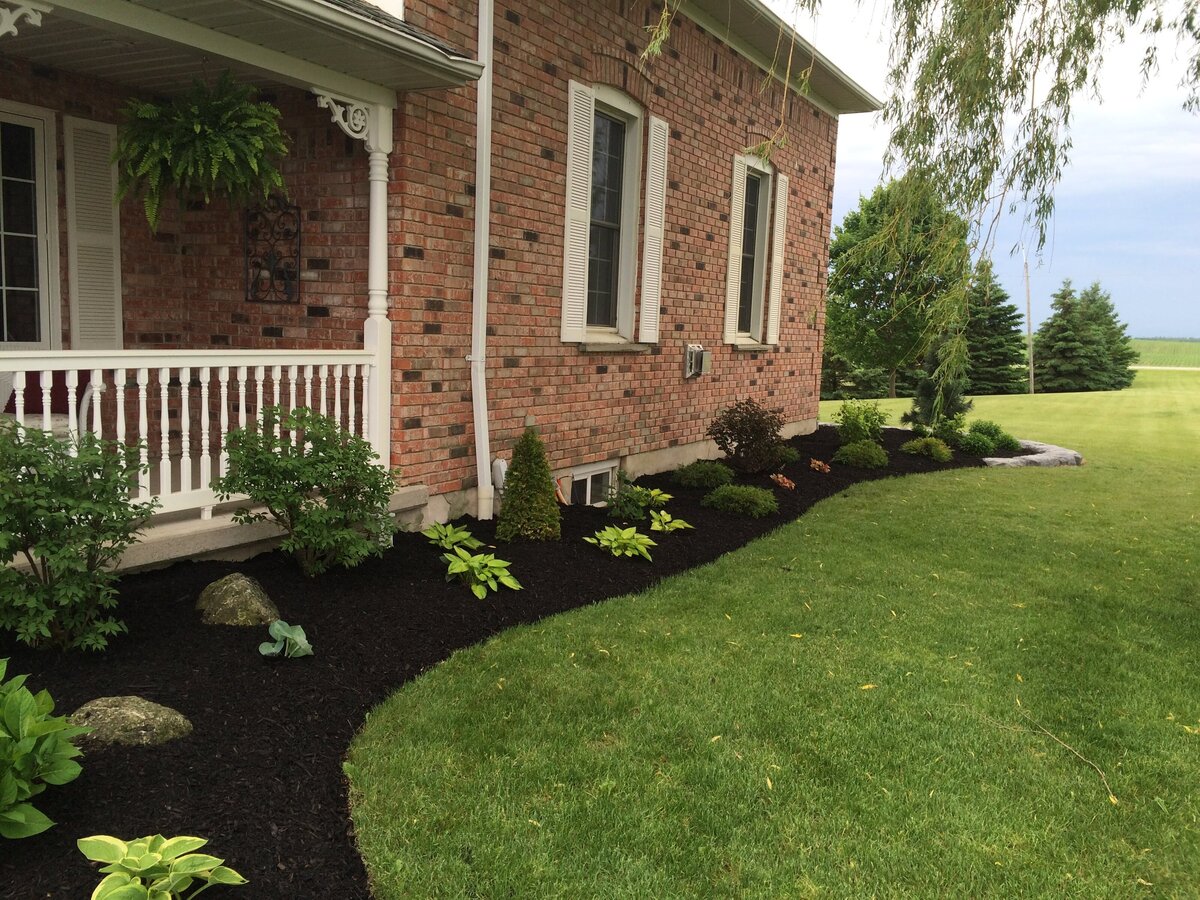 a landscaped garden and backyard with mulch, shrubs, plants by Helena's Gardening