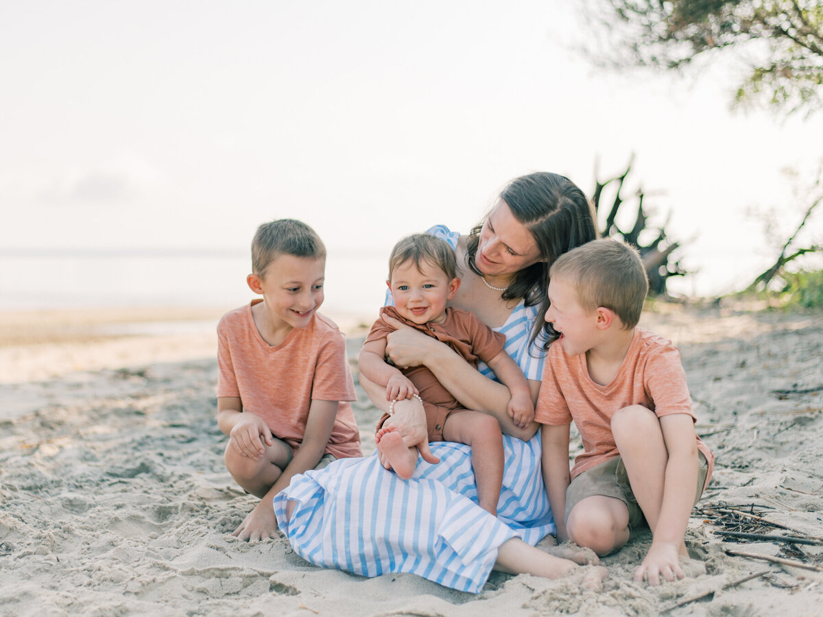 A mom in a blue dress with her three sons during a photo session with a Southern Maryland Photographer