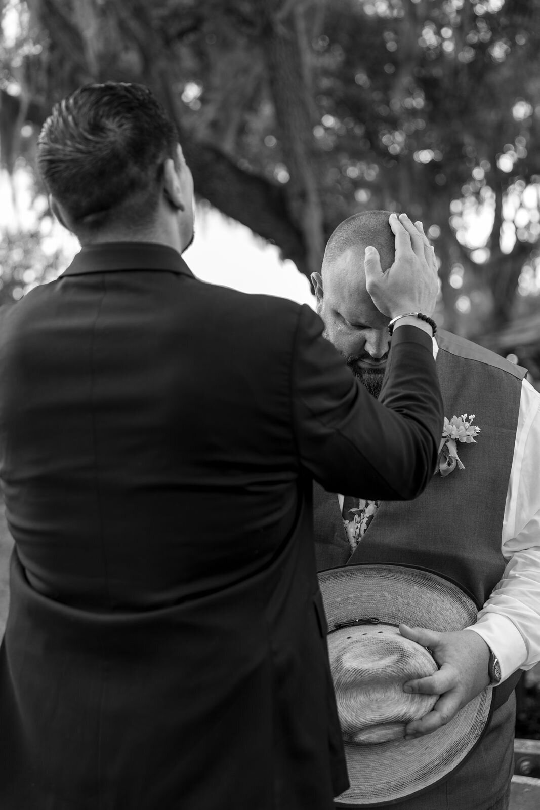 pastor prays with the groom before the wedding ceremony