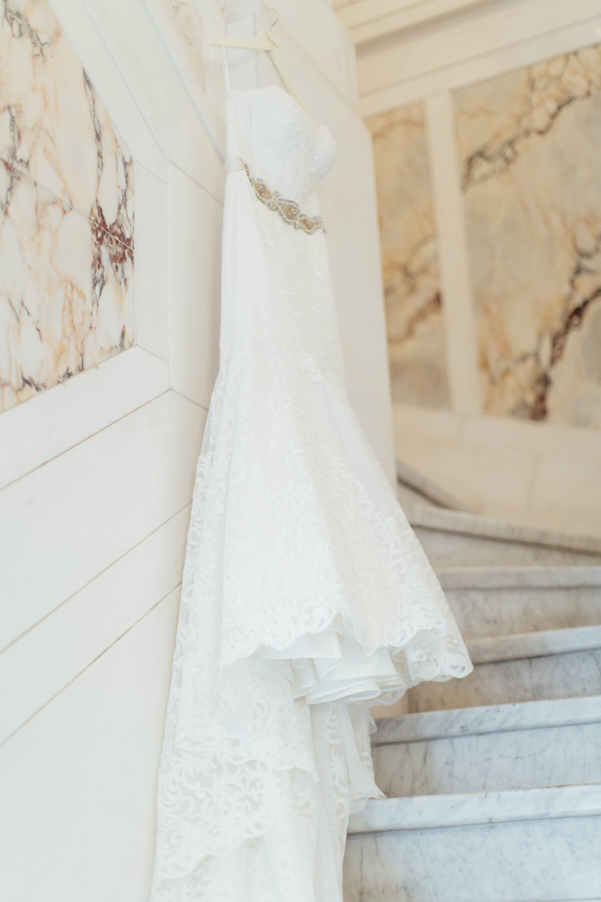 Wedding dress hanging on pretty marble. 