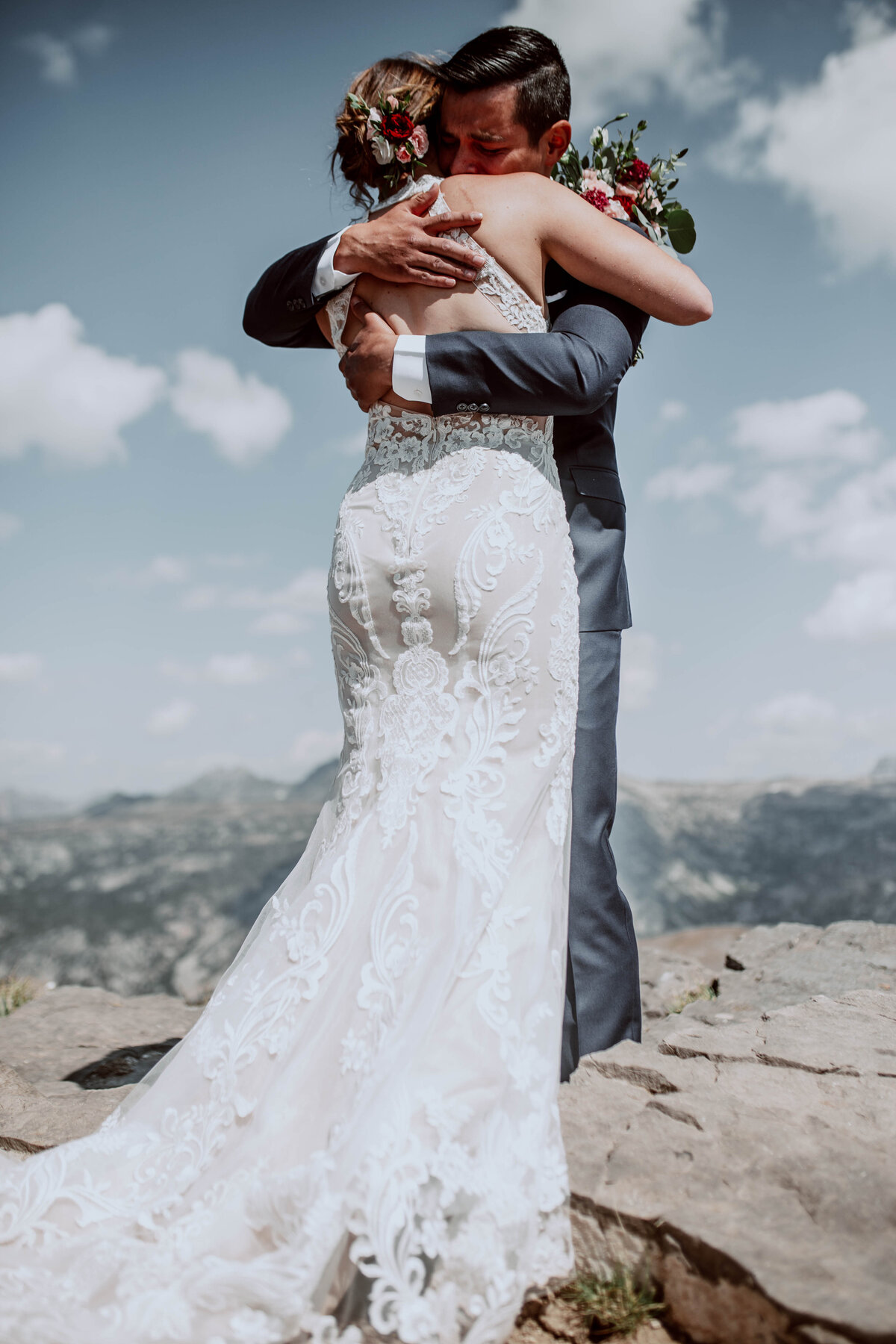Idaho Falls wedding photographer documents bridea lace wedding dress as she stands on the mountain in the Tetons with her groom