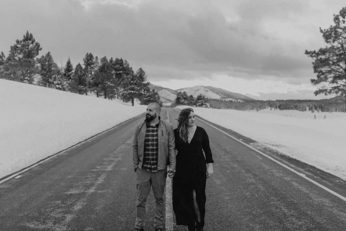 black and white image couple holding hands walking on path