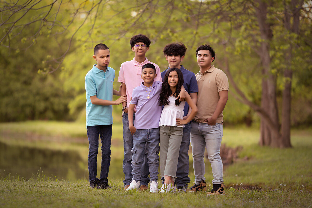 A beautiful family portrait session with siblings by the lake, captured by a Dallas family photographer.