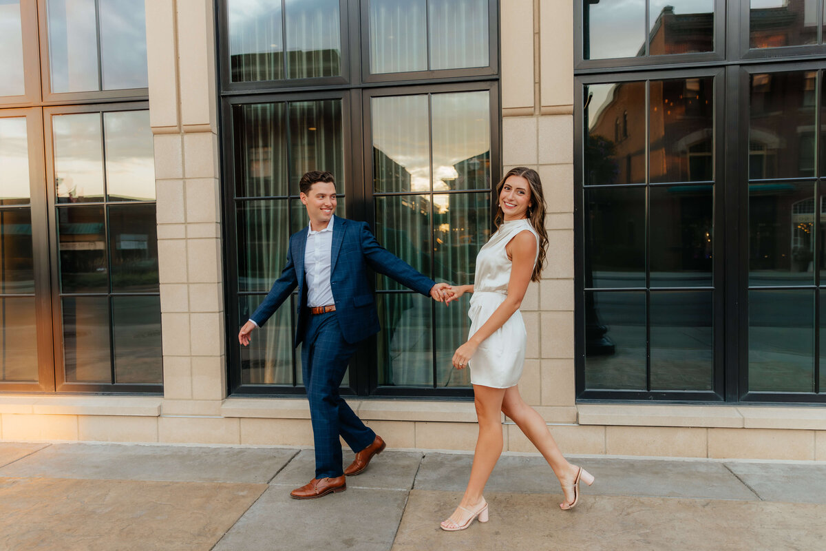 Stylish couple walking through downtown at sunset, elevated Ohio engagement session for couples wanting editorial yet effortless photos