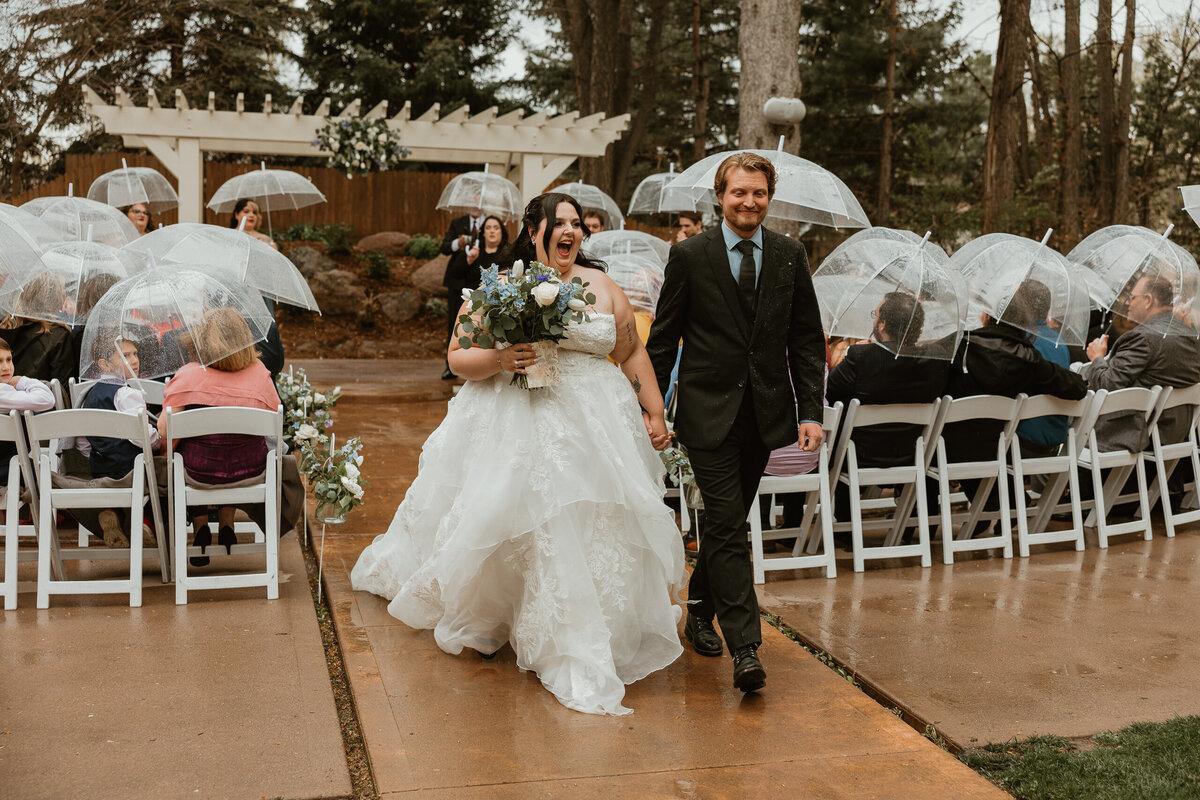 Couple walking down the aisle with excitement after saying their ideas at The Tapestry House in Laporte, Colorado.