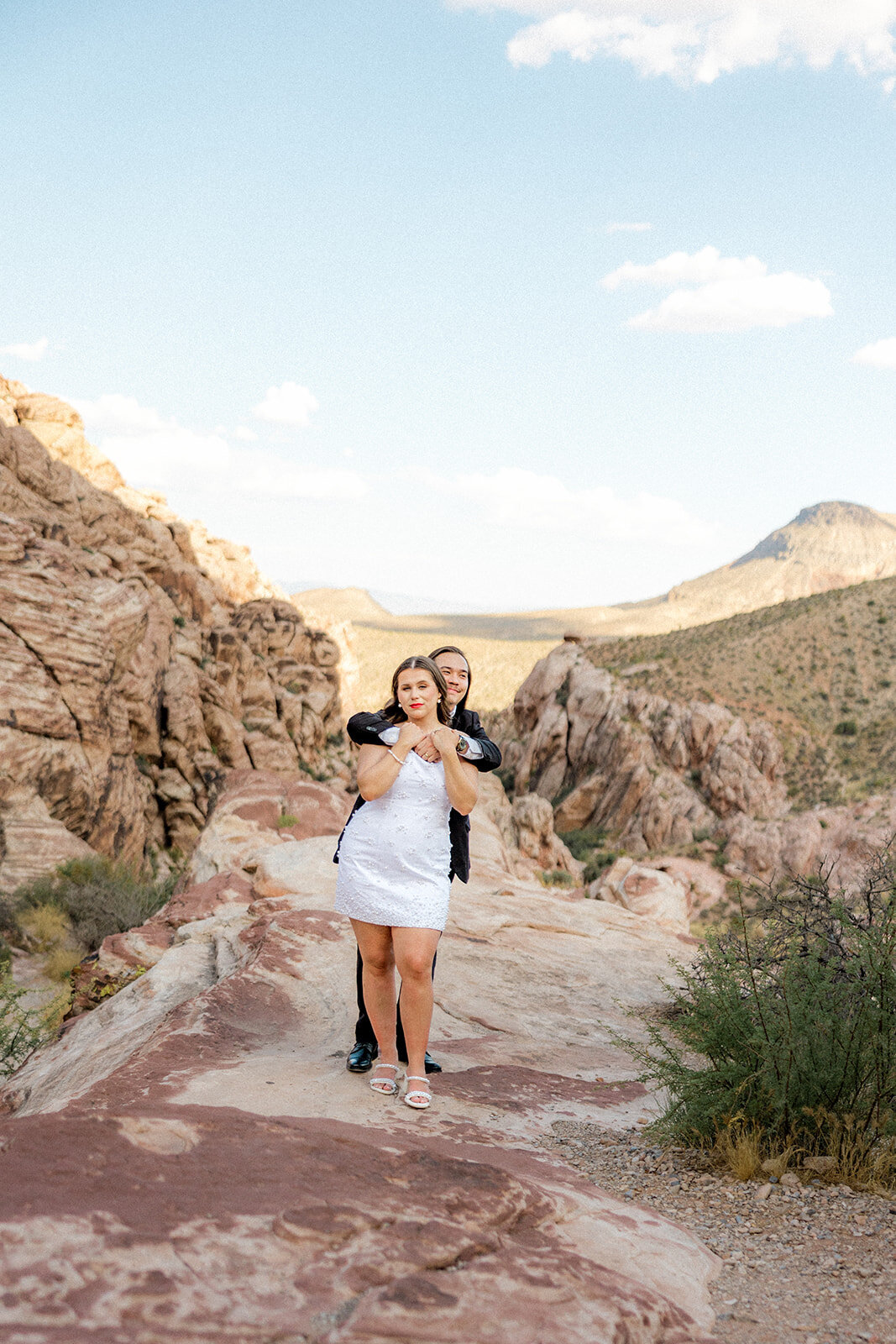 Guy hugging his fiance from behind at the Red Rock Canyon