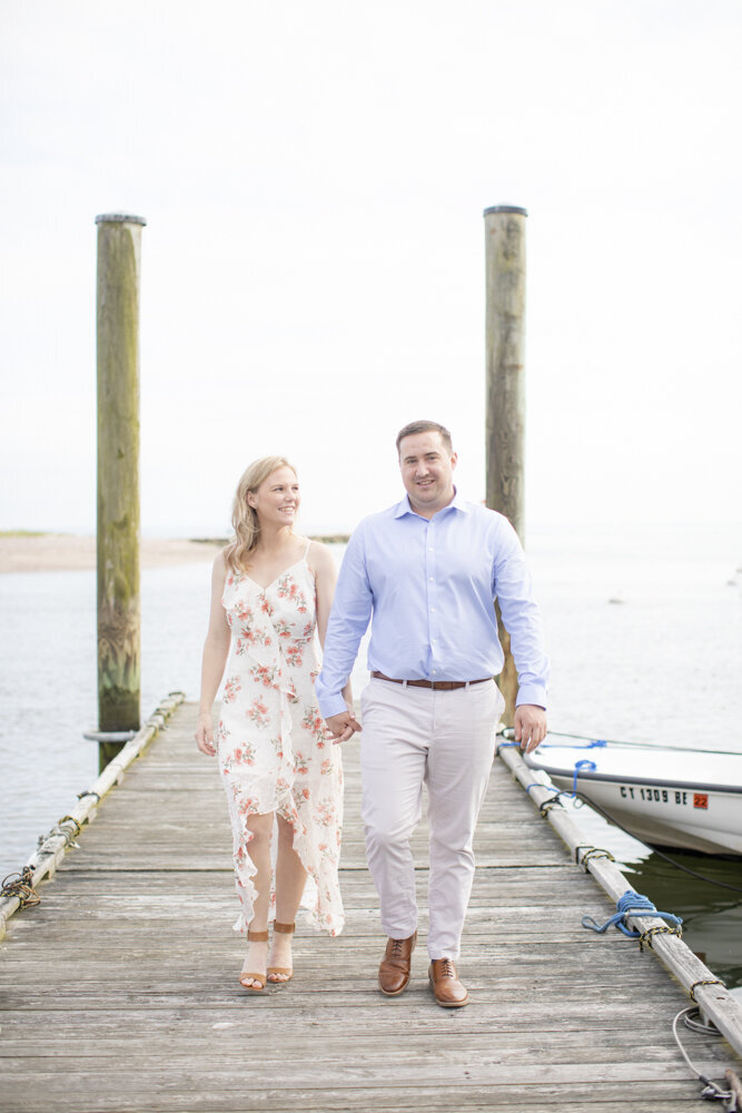 couple walking on the dock at boat marina for engagement  portraits