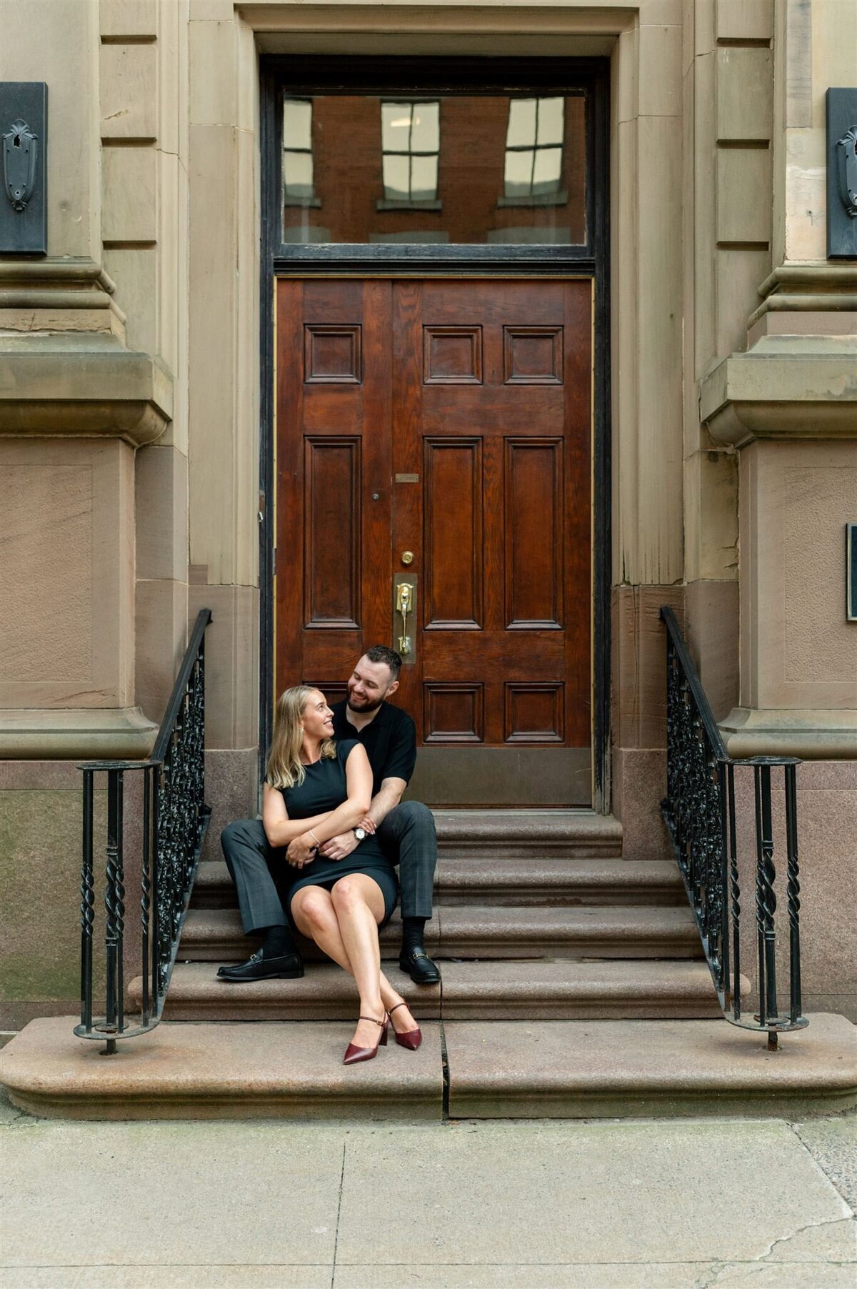 Couple pose for portraits on the steps of Halifax Club