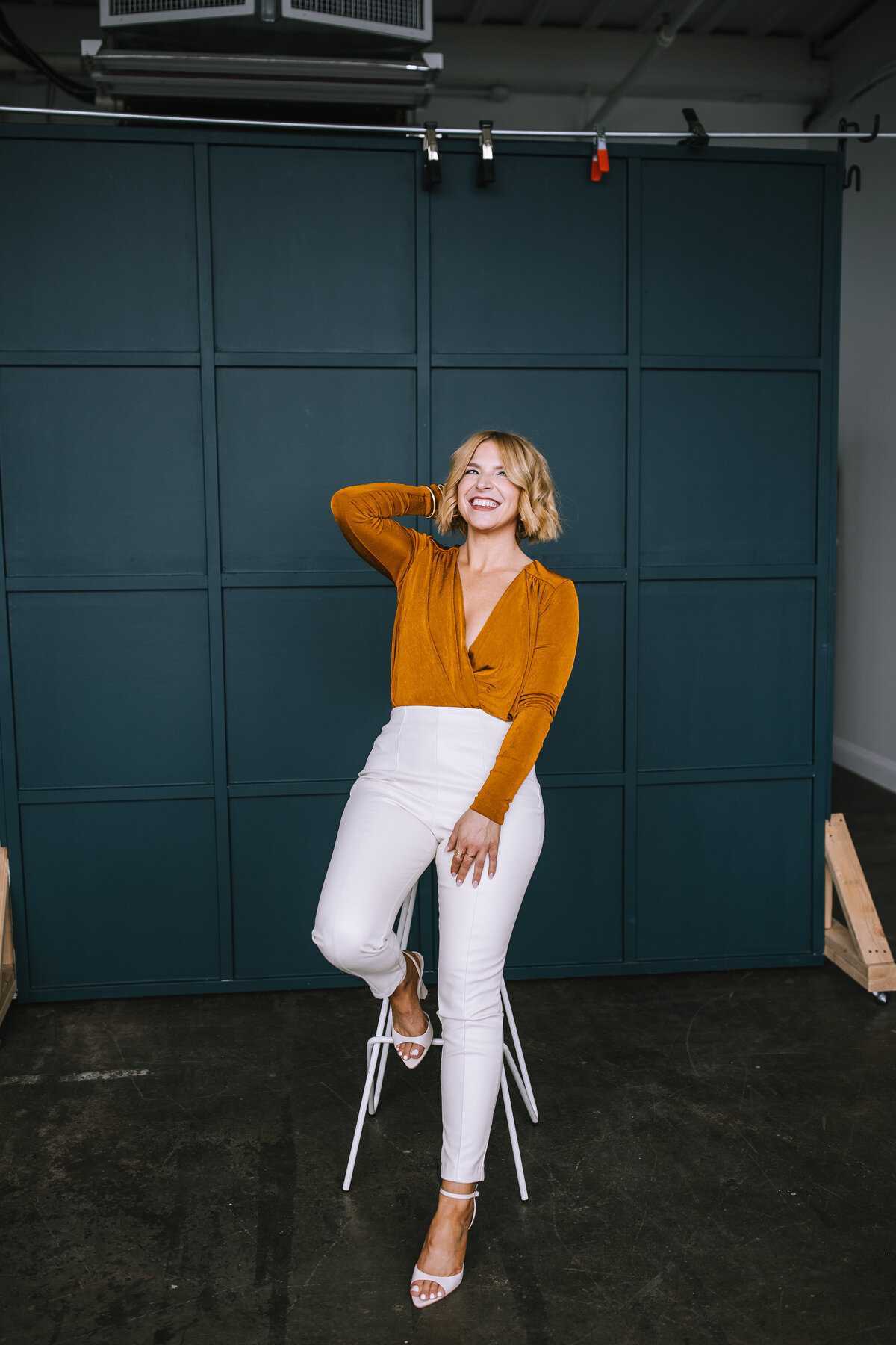 Woman sitting and laughing on a stool for her brand photos for her Pittsburgh small business.