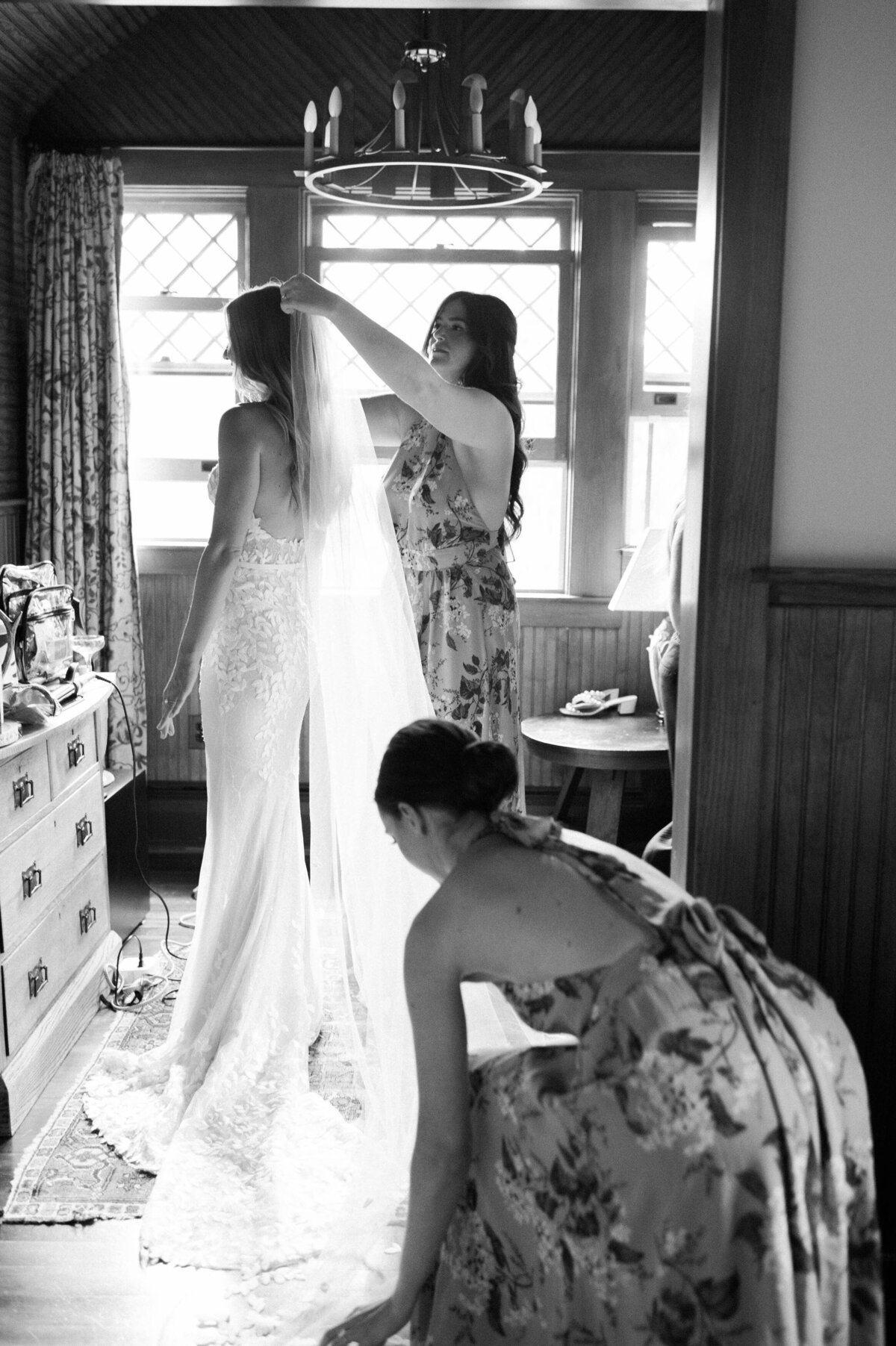 Bridesmaid helps bride attach her veil