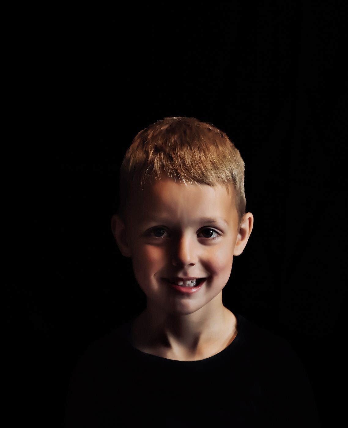 Portret van een jonge jongen tegen een zwarte achtergrond