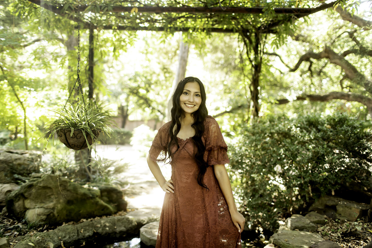 A stunning senior photoshoot in the tranquil setting of Chandor Gardens, with the graduate glowing in a soft, flowing dress against a backdrop of blooming flowers