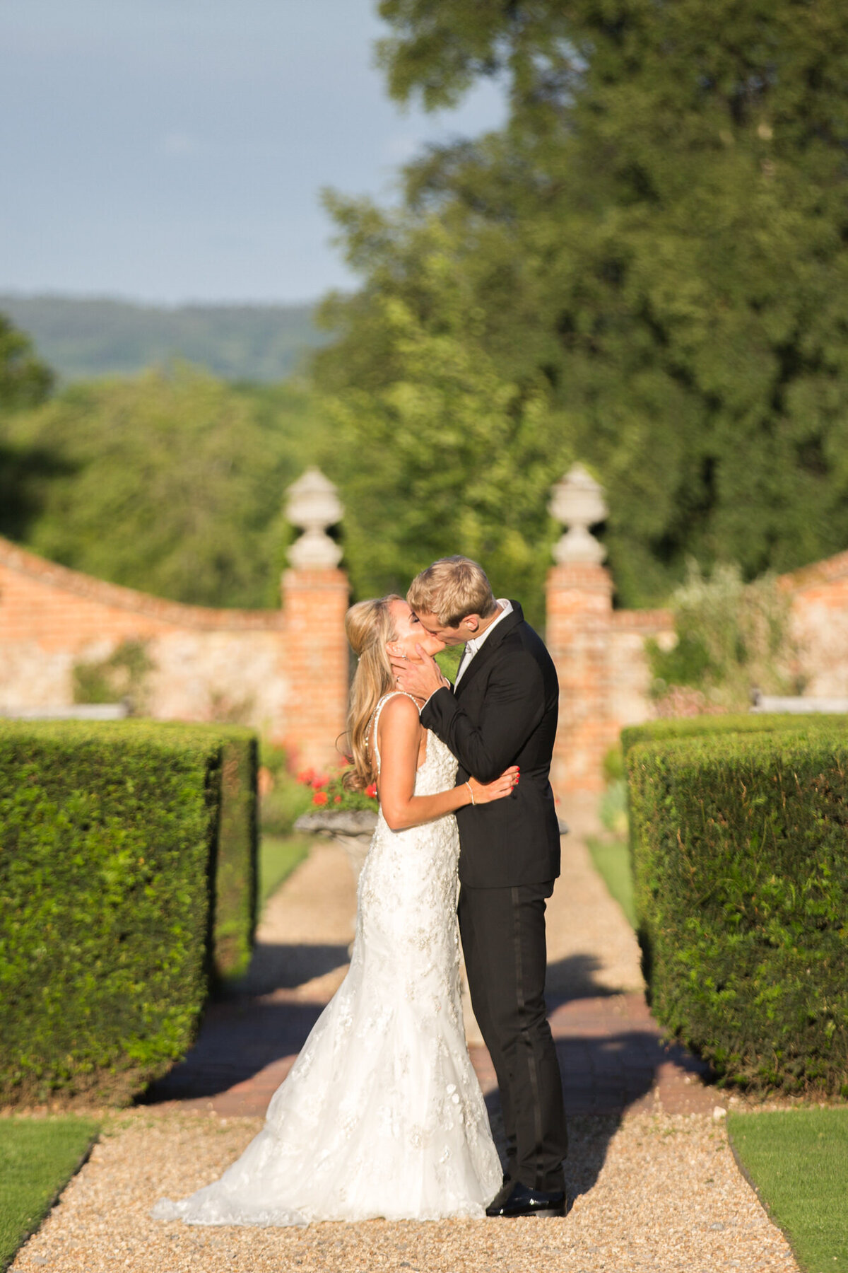 Groom giving bride a kiss in garden