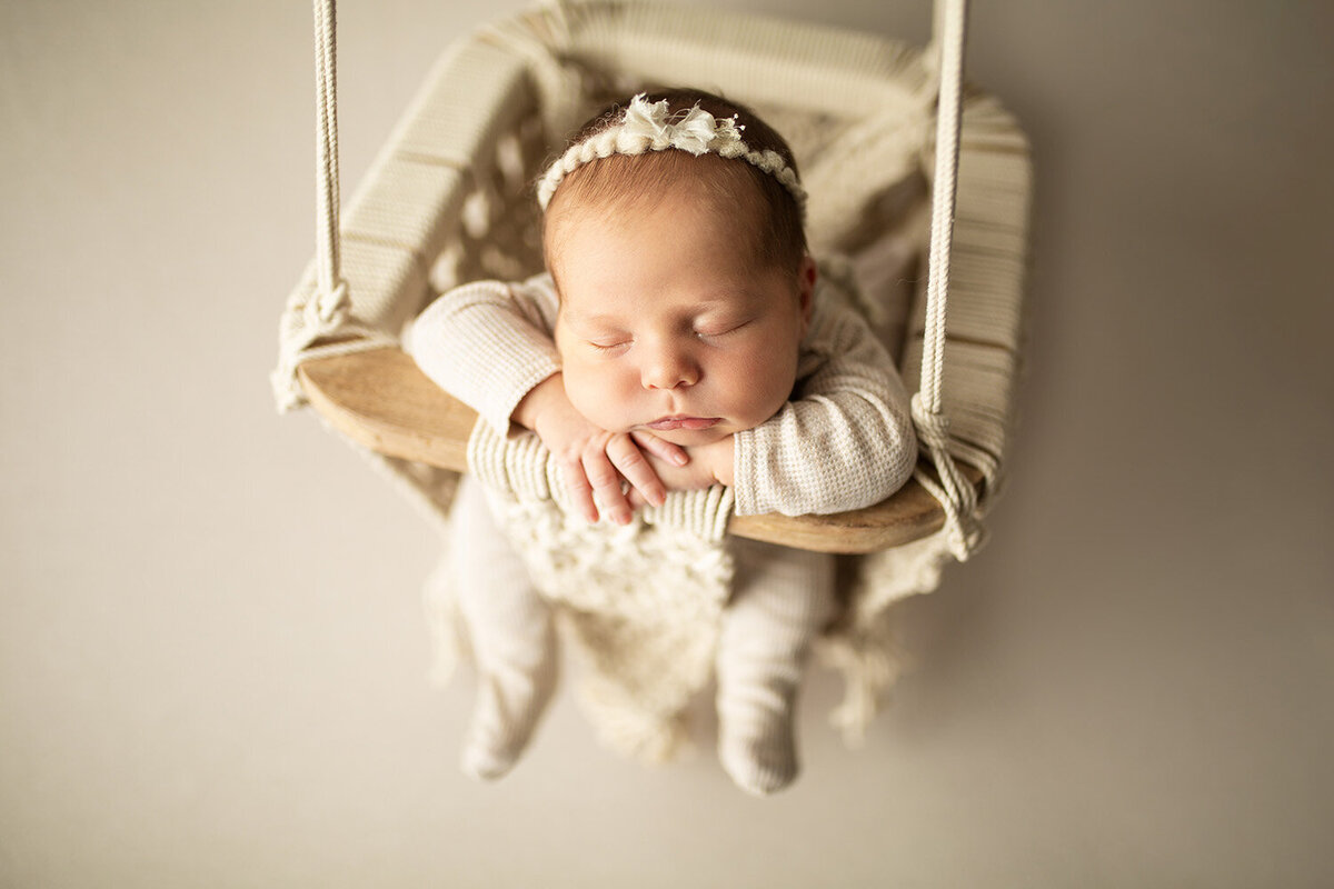 newborn sleeping in boho swing