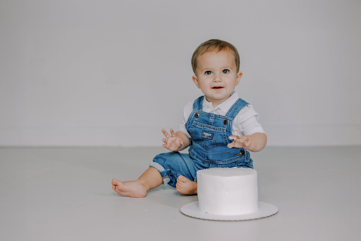 Baby boy poses during his cake smash photo session in Richmond, VA.