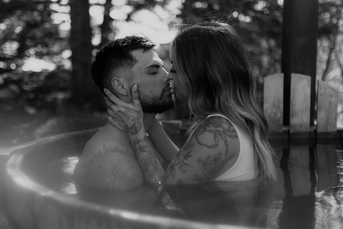 black and white image couple kissing in tub