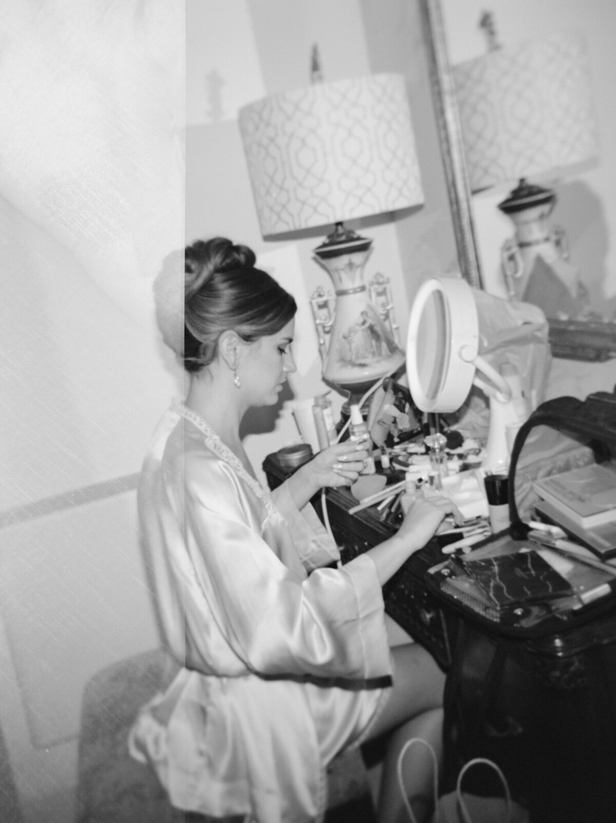Detroit film wedding photography of a bride in silk robe doing her makeup