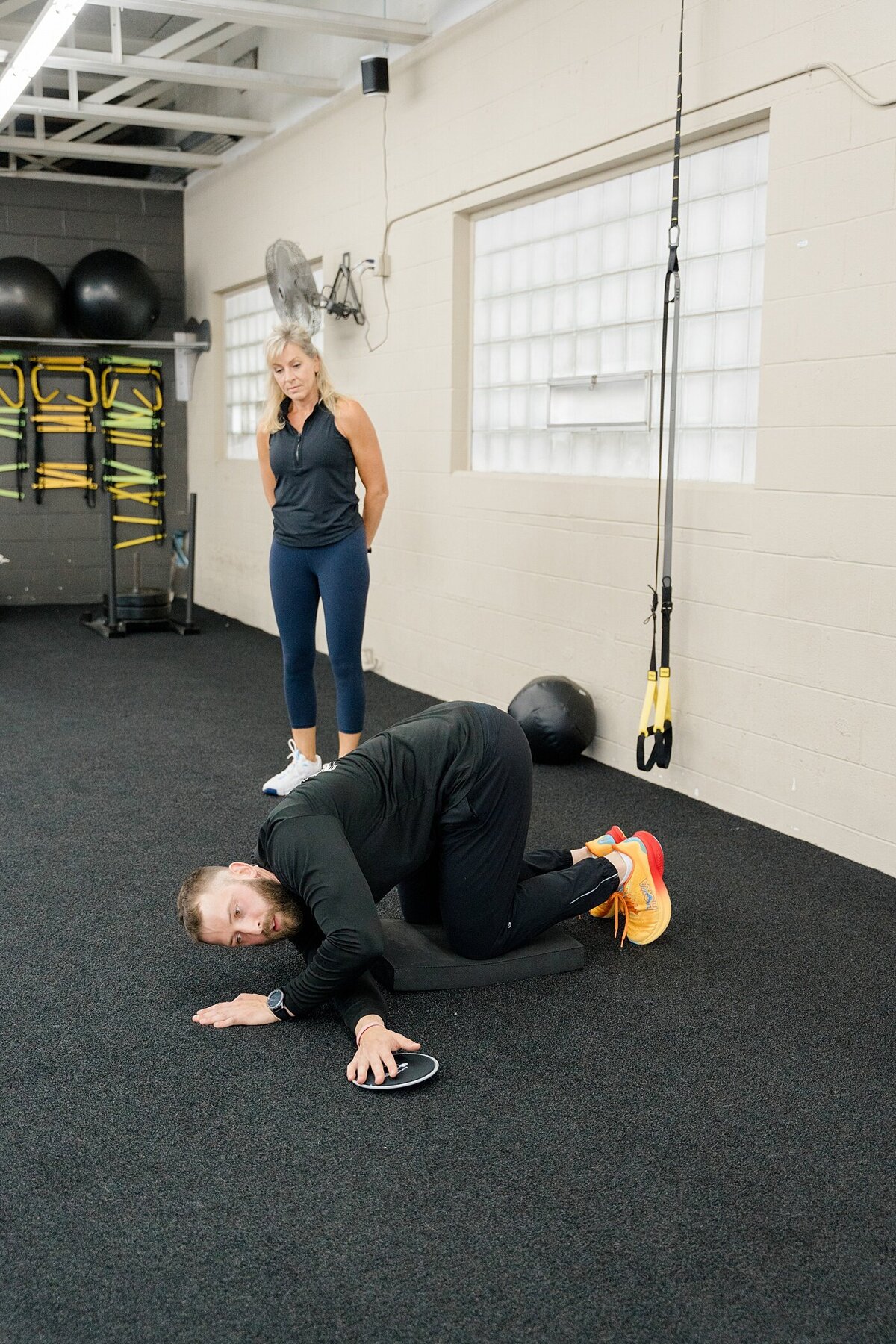 personal trainer stretches and trains a client in a gym photographed by Columbus photographer