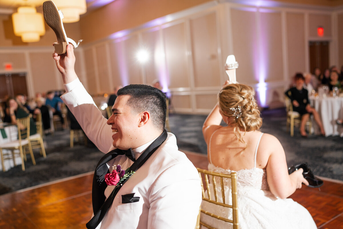 Bride and groom laugh while playing the shoe game at their wedding at Nationwide Hotel and Conference Center in Lewis Center, Ohio.
