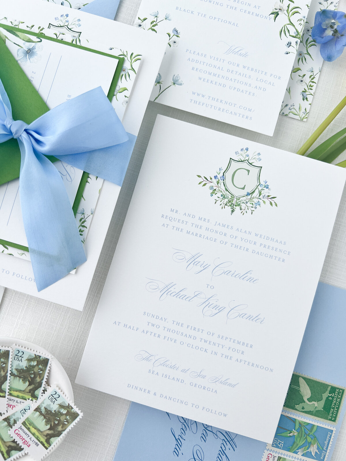 a wedding invitation with a monogram crest at the top