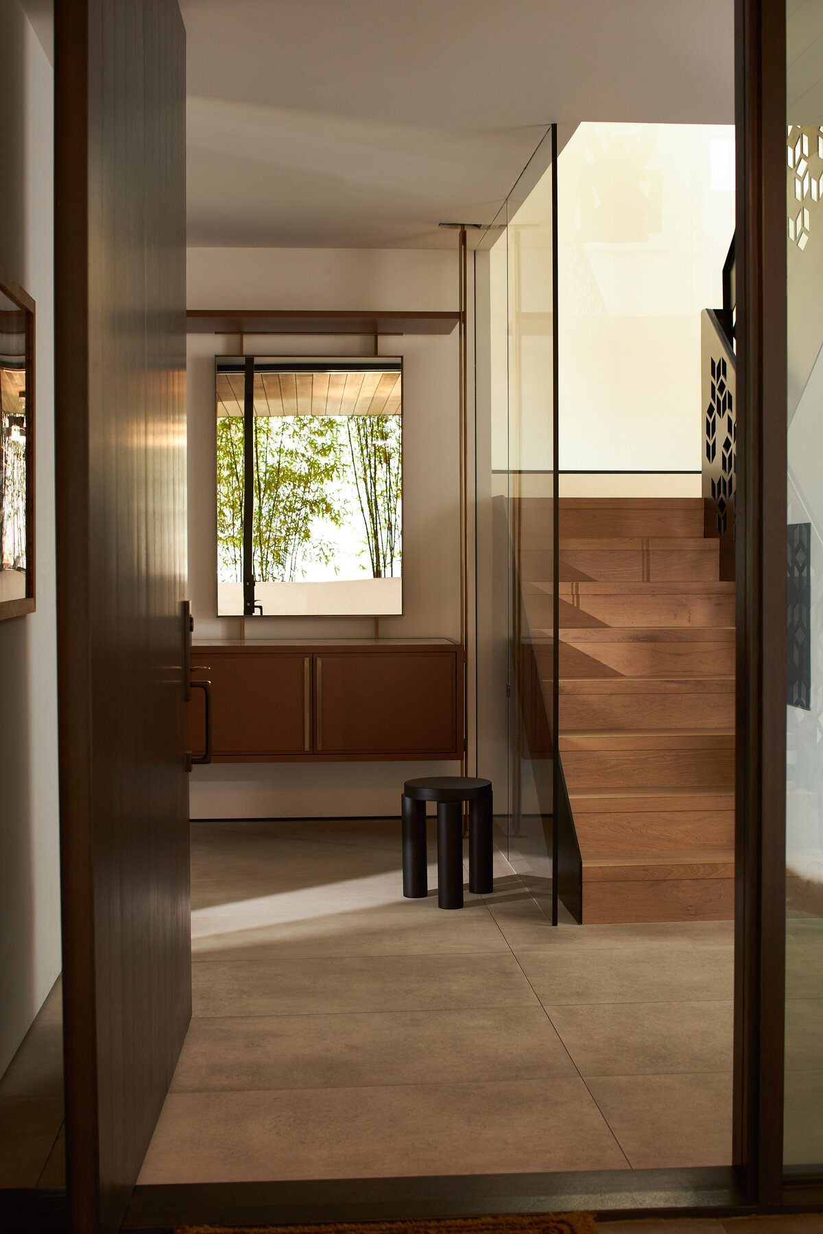 Modern entryway with wooden staircase and minimalist design, captured in interior photography