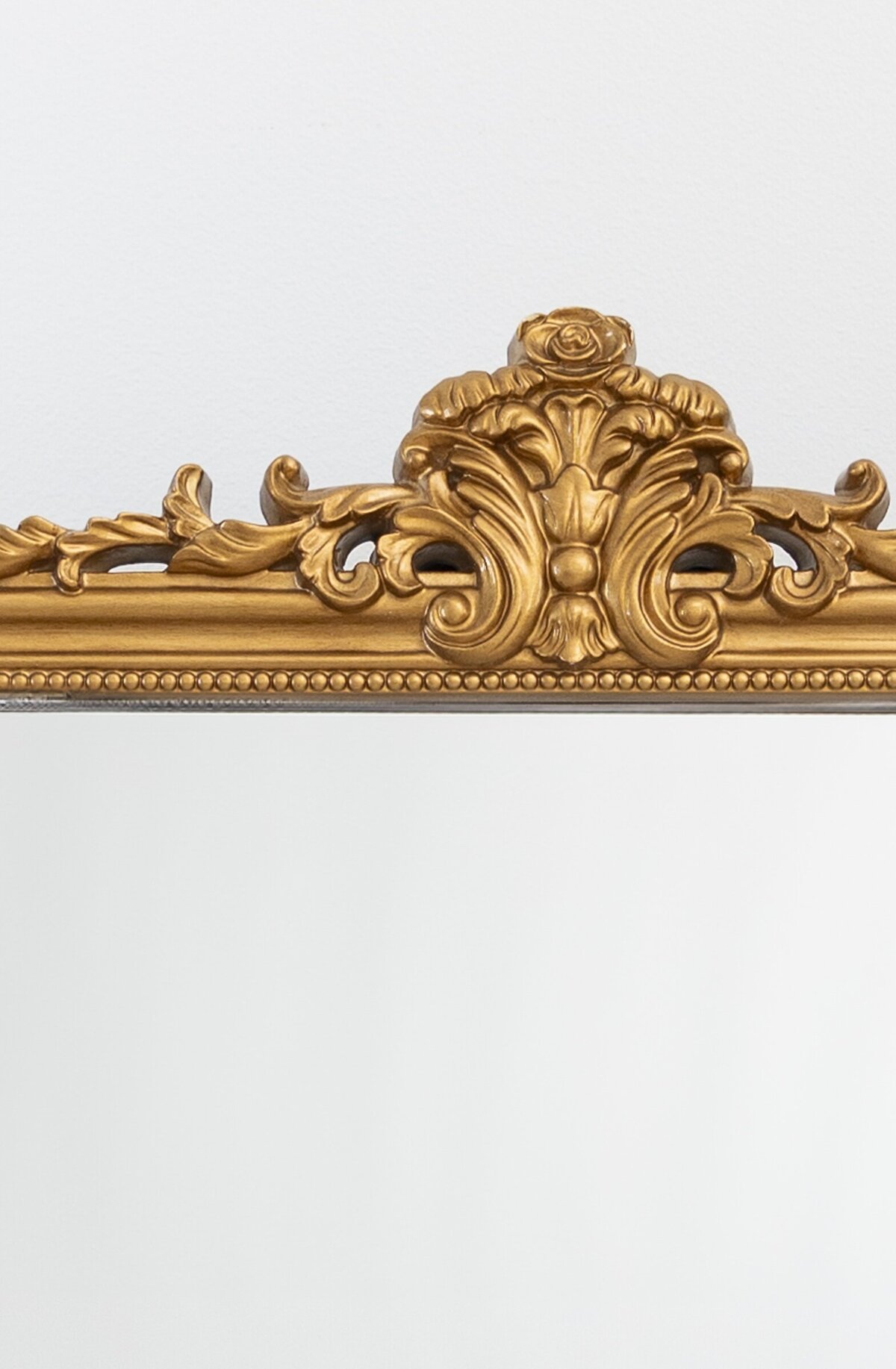 Medium horizontal mirror with ornate ornament on top 