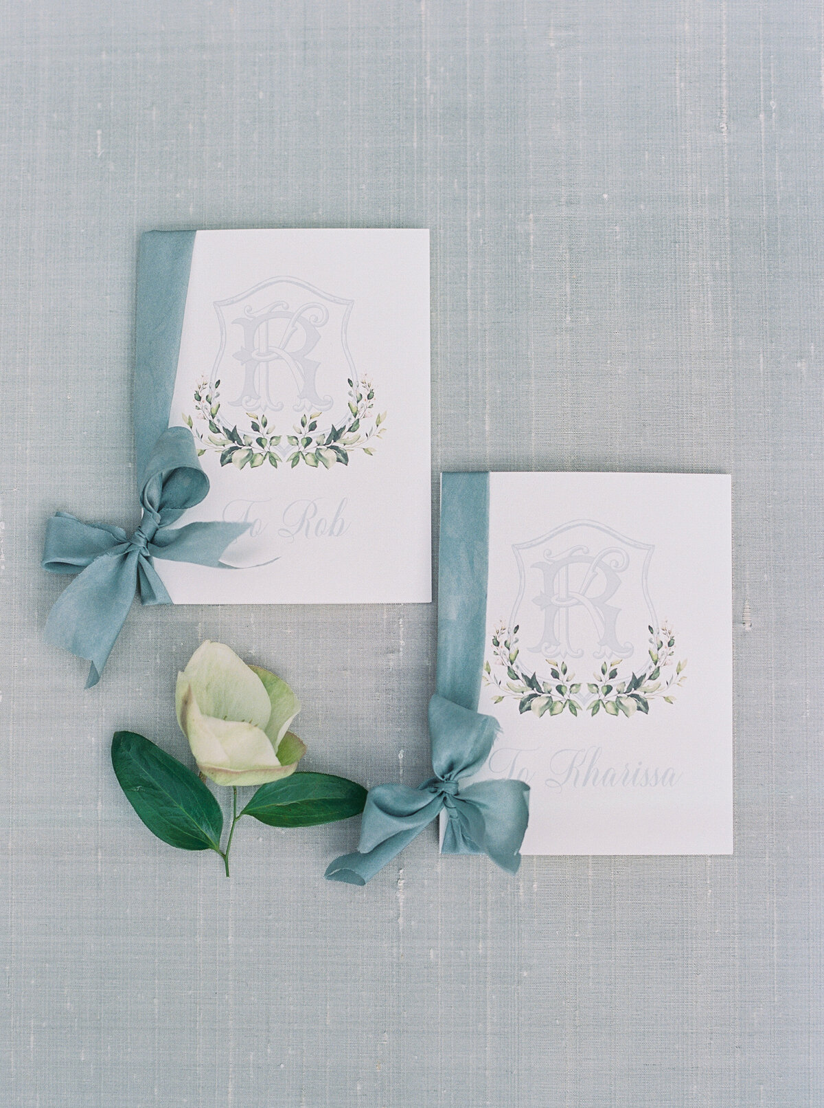 Exquisite wedding vow books with a personalized monogram and soft blue ribbon accents. A beautiful detail for a luxury wedding ceremony and keepsake.